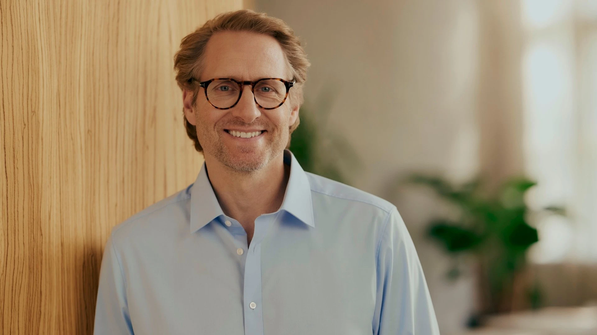 Portrait of a smiling decision-maker from an energy supply company in a modern business environment. He symbolises the digitalisation of energy providers and demonstrates how a modern CRM for energy providers supports customer experience, efficient processes and sustainable customer relationships.
