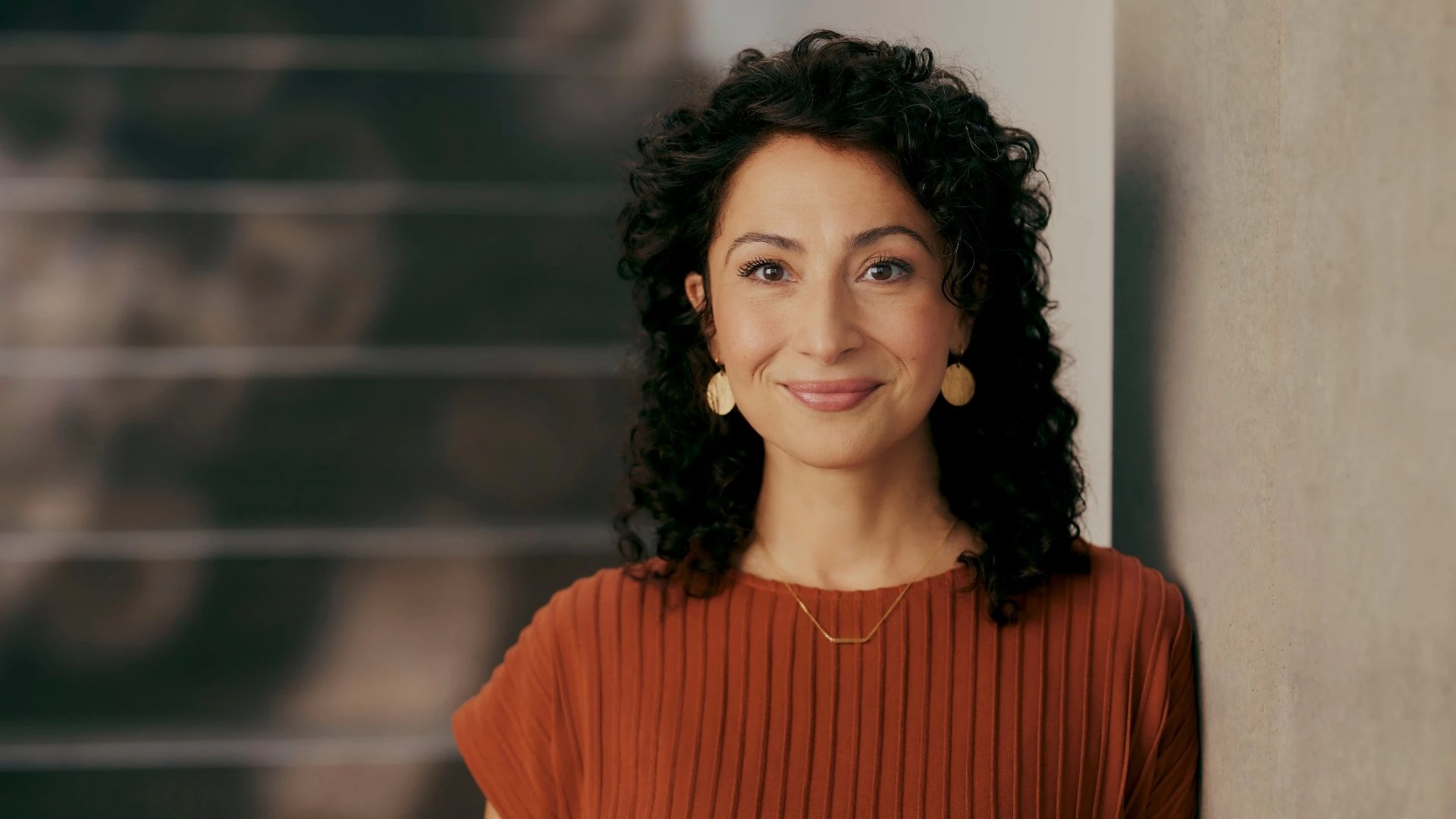 Portrait of a smiling woman in a modern business environment. She symbolises a decision-maker in the insurance industry who is driving digitalisation in insurance with a modern CRM for insurance.