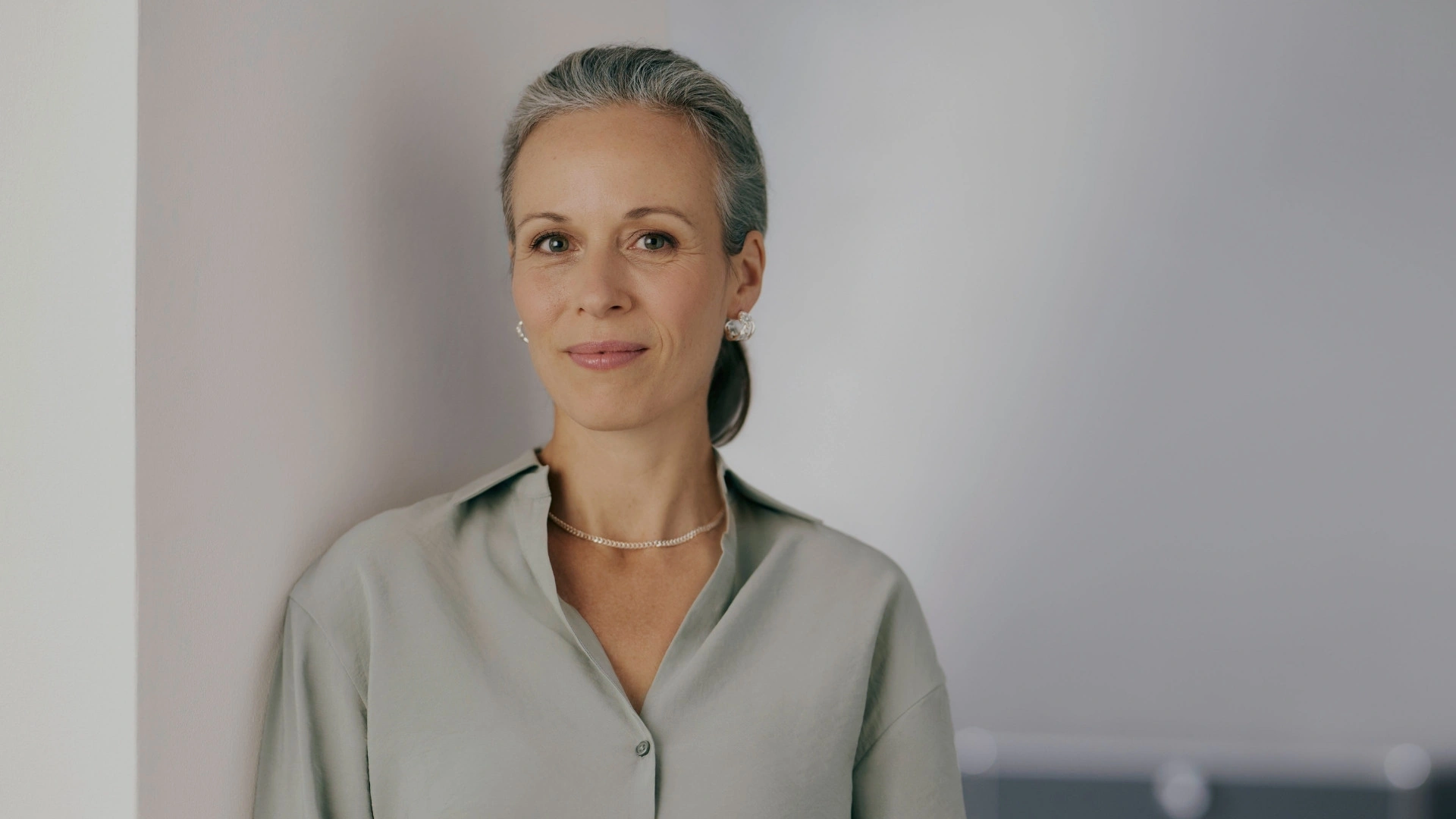 Portrait of an experienced woman in a modern business environment. She symbolises a decision-maker in the financial sector who is driving digitalisation in banking with a CRM for banks and financial service providers that seamlessly integrates core banking systems.