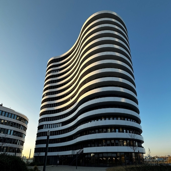 BSI Software Standort in Düsseldorf – modernes, wellenförmiges Hochhaus mit markanter schwarz-weisser Fassadenstruktur im MedienHafen.